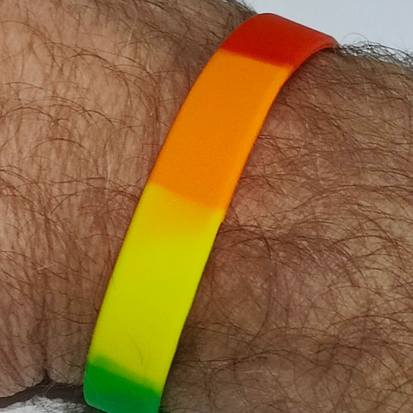 gay wristband on mans arm close up